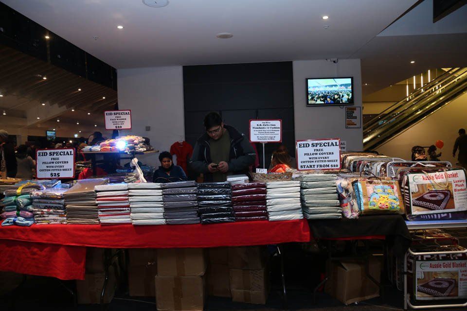 A man is standing in front of a table with lots of items on it.