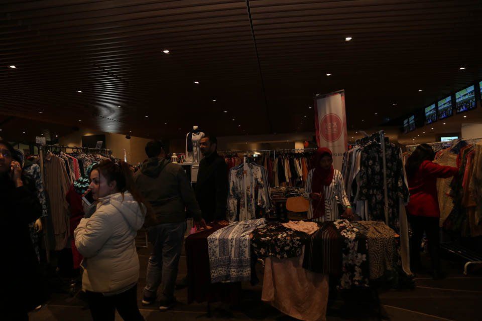 A group of people are shopping at a clothing store.