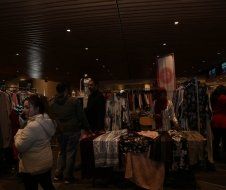 A group of people are standing around a clothing store.