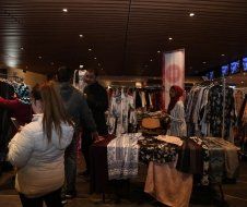 A group of people are standing around a table in a store.