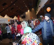 A group of people are standing in a room with balloons.