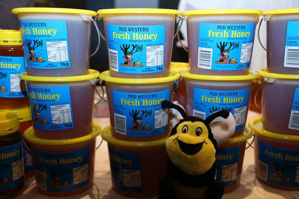 Buckets of fresh honey are stacked on top of each other