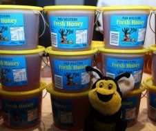 Buckets of fresh honey are stacked on top of each other on a table.