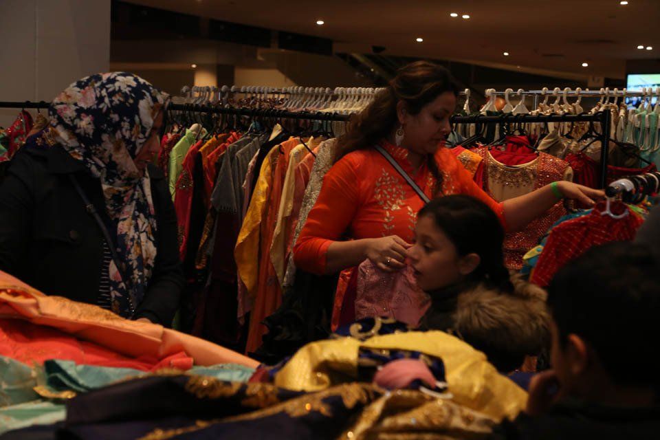 A group of people are looking at clothes in a store.