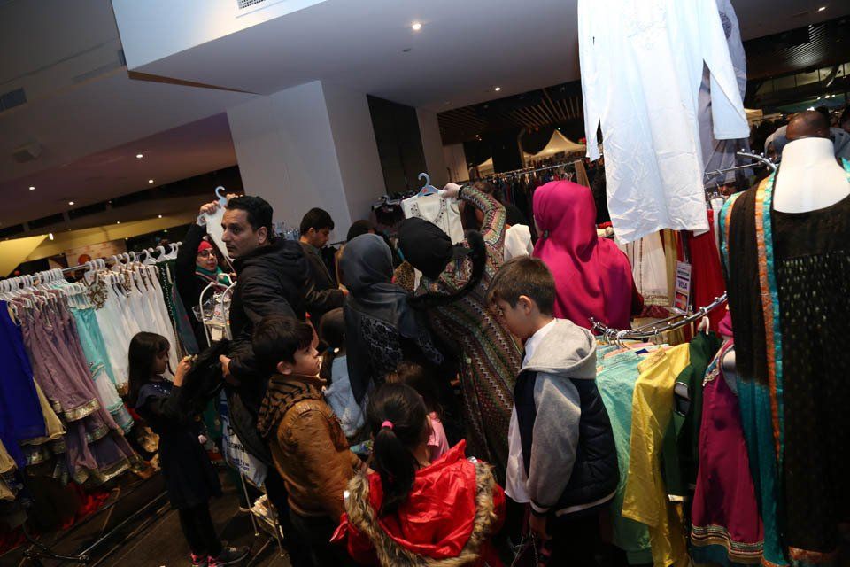 A group of people are looking at clothes in a store.