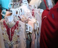 A row of clothes hanging on a rack in a store.