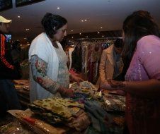 A group of people are looking at clothes in a store.
