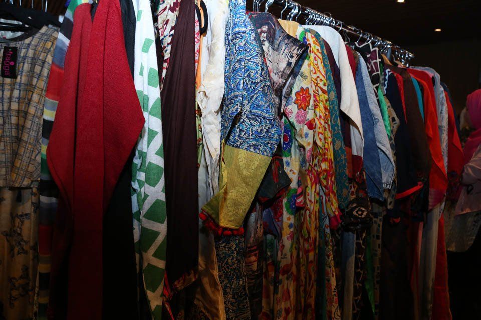 A row of colorful clothes hanging on a rack in a store.