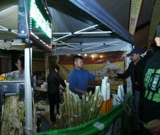 A group of people are standing around a tent selling food