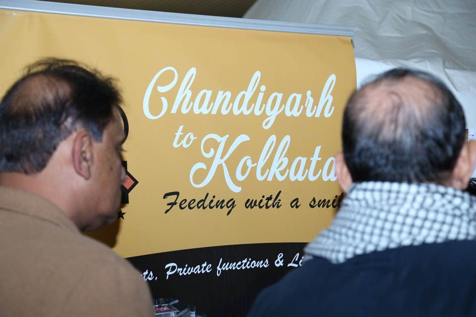 Two bald men looking at a sign that says chandigarh to kolkata