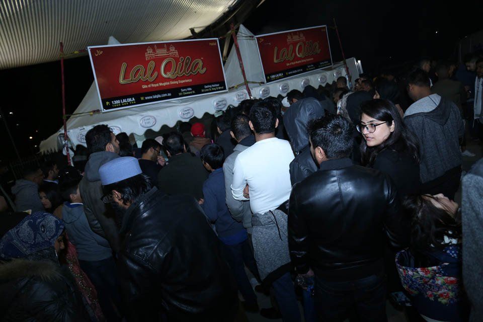 A large group of people are standing in front of a tent.