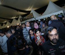 A crowd of people are standing in a tent at a festival.