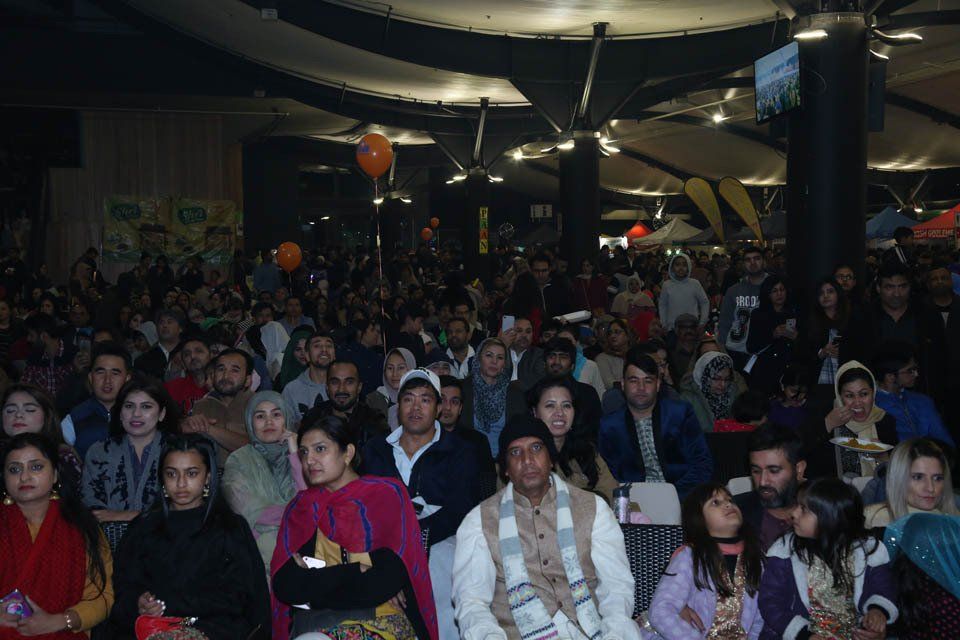 A large group of people are sitting in a dark room