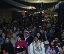A large group of people are sitting in a room watching a presentation.