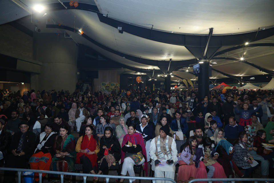 A large crowd of people are sitting in a large room