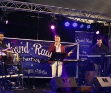 A man is standing on a stage holding a microphone.