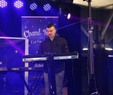 A man is playing a keyboard on a stage.