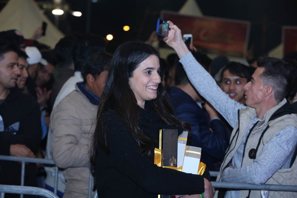 A woman taking a picture of a man with her phone