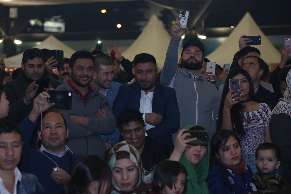 A crowd of people taking pictures with their cell phones