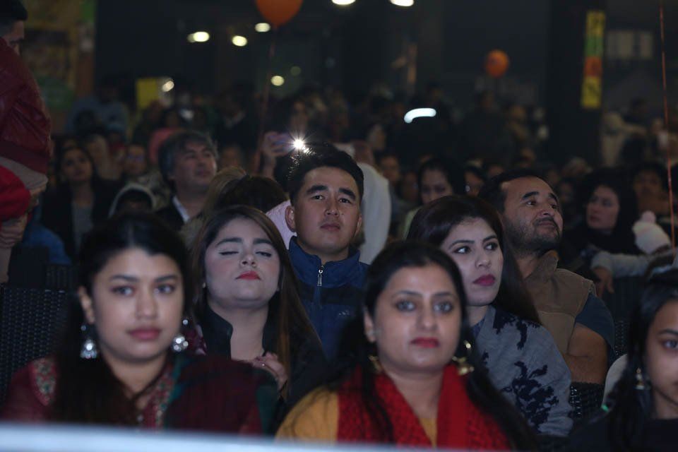 A crowd of people are sitting in a stadium watching a concert.
