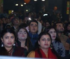 A large group of people are sitting in a dark room.
