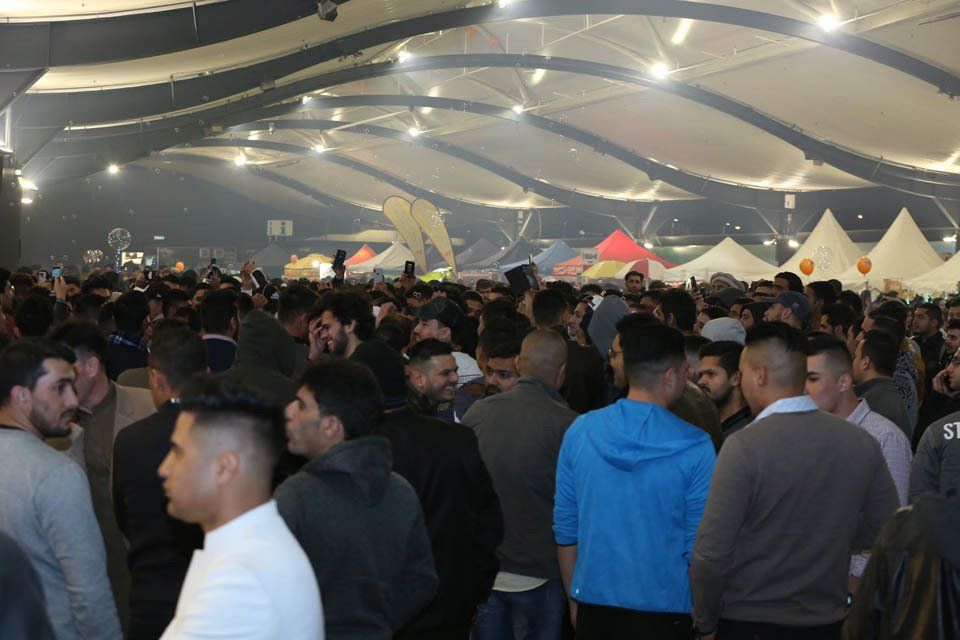 A large group of people are standing in a large room.