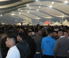 A large group of people are standing in a large room.