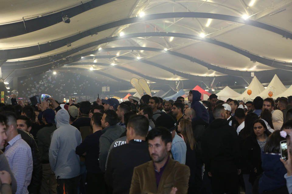 A large group of people are standing in a large room.