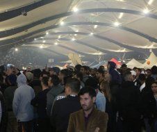 A large group of people are standing in a large room.