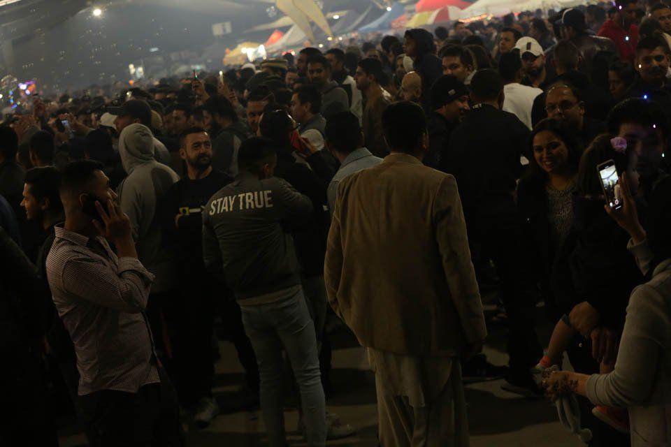 A crowd of people are standing in a dark room.