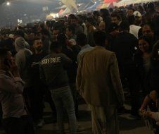 A crowd of people are standing in a dark room.