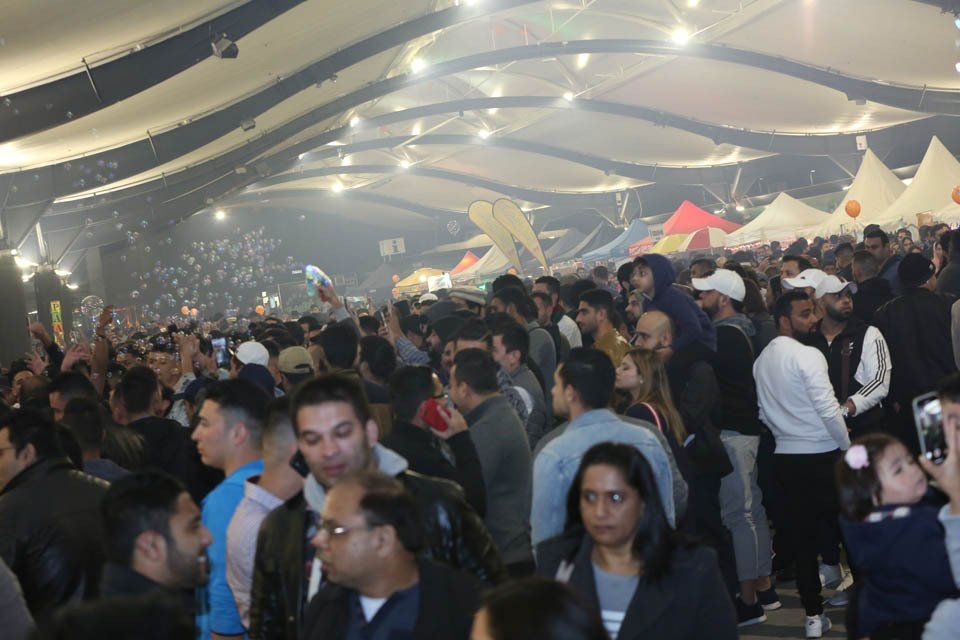 A crowd of people are gathered in a large room.