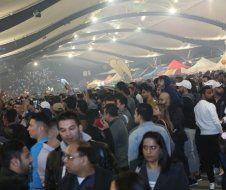 A large group of people are standing in a large room.