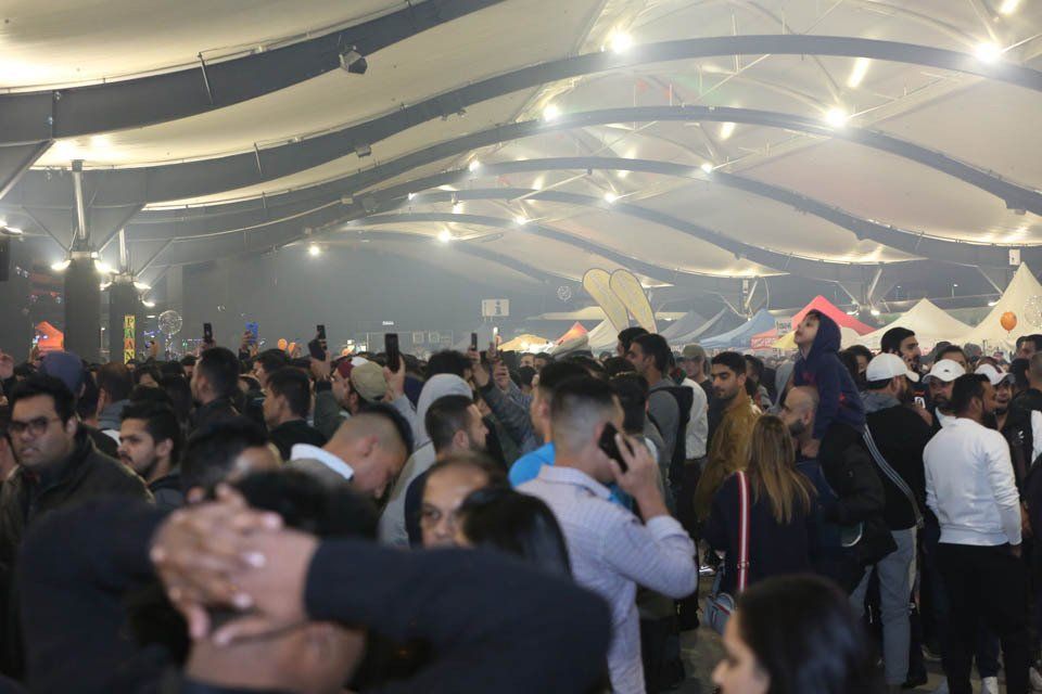 A large group of people are dancing in a large room.