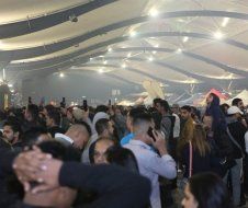 A large group of people are standing in a large room.