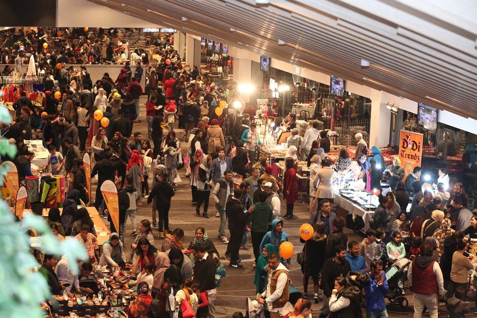 A large crowd of people are gathered in a large room.