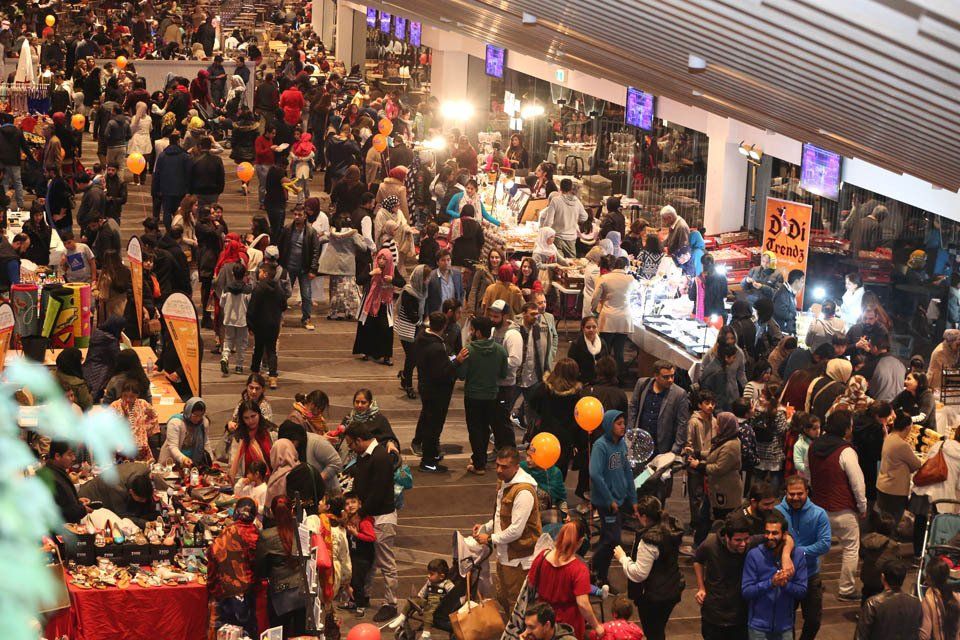 A large crowd of people are gathered at a market.