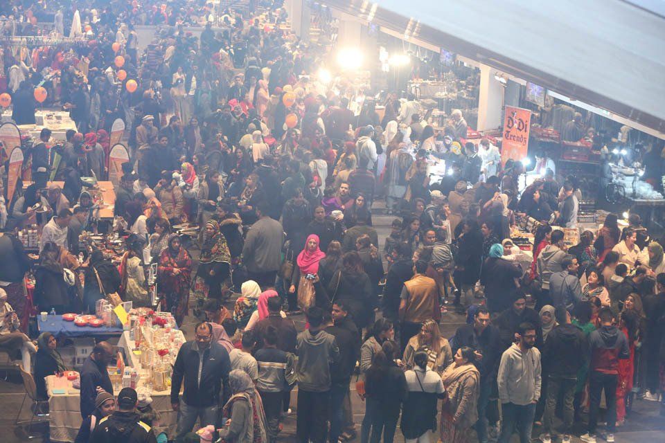 A large crowd of people are gathered at a market.