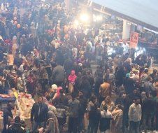 A large crowd of people are gathered at a market.