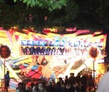 A group of people are standing in front of a carnival ride.