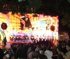 A crowd of people are standing in front of a large screen.