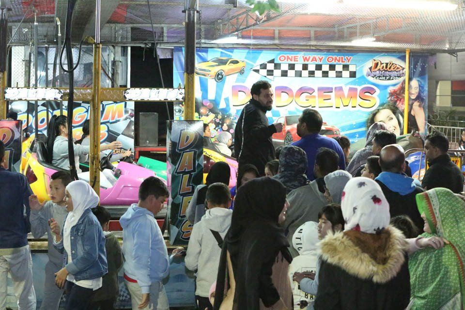 A crowd of people are gathered in front of a sign that says edgems