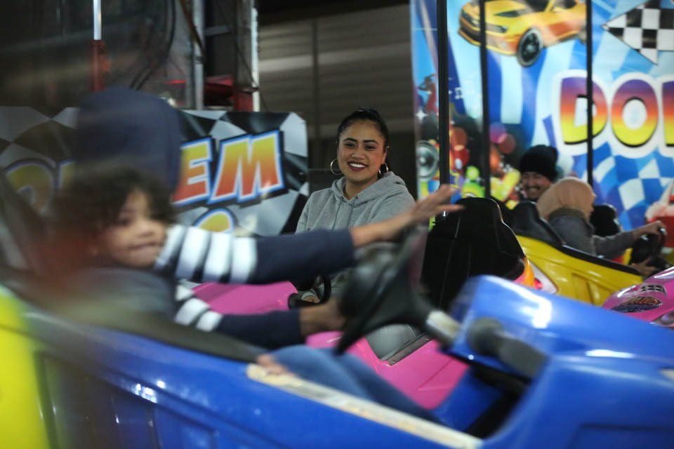 A group of people are riding a bumper car at an amusement park.