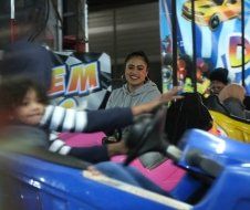 A group of people are riding a bumper car at an amusement park.