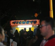 A group of people are standing in front of a ticket booth.