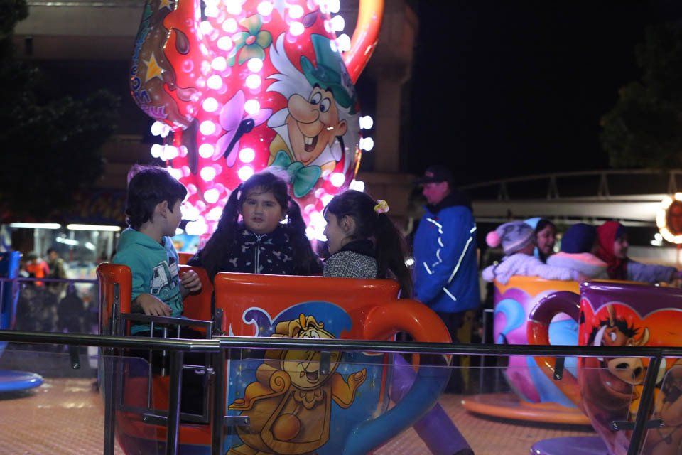 A group of children are riding a carnival ride at night
