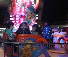 A group of children are riding a carnival ride at night