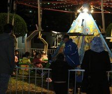 A group of people standing in front of a teepee at night
