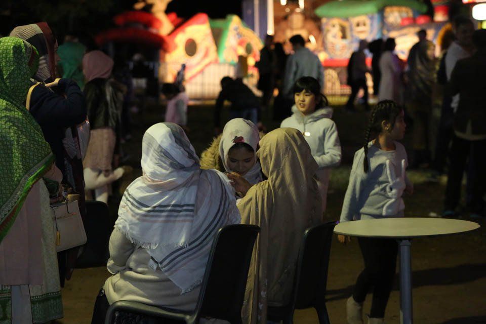 A group of people are sitting around a table at night.
