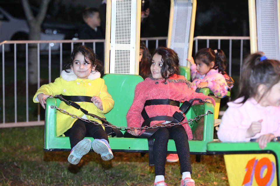 A group of young girls are riding a ferris wheel at night.